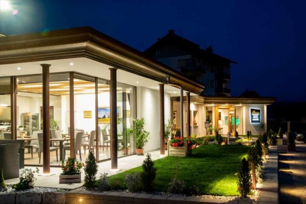 Moderní restaurace s prosklenou stěnou osvětlená v noci.
