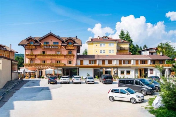 Hotel s parkovištěm a klidným okolím pod modrou oblohou.