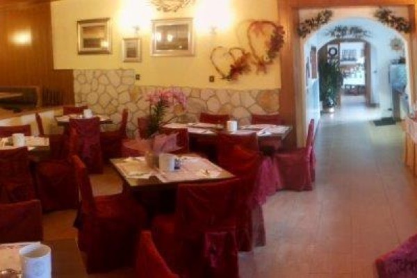 Interiér restaurace s červenými židlemi a dekoracemi na zdech.  