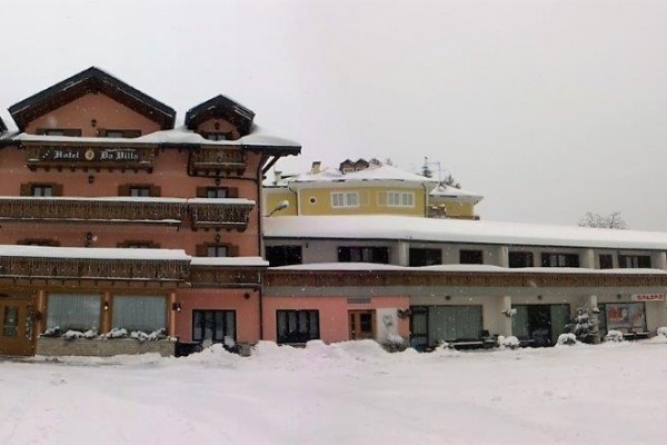 Budova hotelu pokrytá sněhem v zimní krajině.