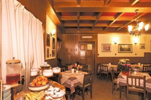 Restaurace s dřevěným obložením, prostřenými stoly a nápoji na bufetovém stole.