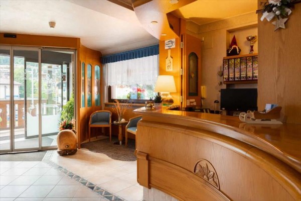 Recepce hotelu s dřevěným nábytkem a dekoracemi.