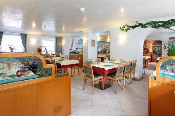 Restaurace s dřevěným nábytkem a dekorativními prvky na stěnách.  