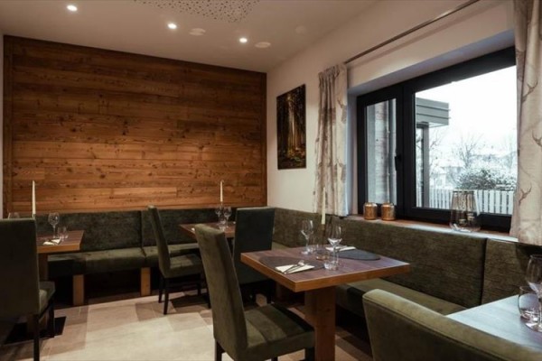Moderní restaurace s dřevěným obložením a prostřenými stoly.