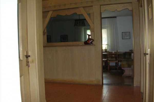 Chodba s dřevěným průhledem do vedlejší místnosti.