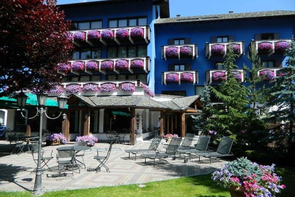 Vchod do horského hotelu s dřevěnými detaily a balkony.