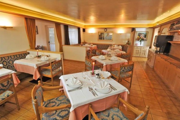 Restaurace s dřevěným nábytkem a stoly připravenými k servírování.