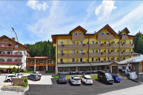 Velký hotelový komplex s parkovištěm obklopený přírodou.