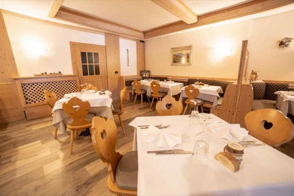 Restaurace se dřevěným nábytkem a prostřenými stoly.