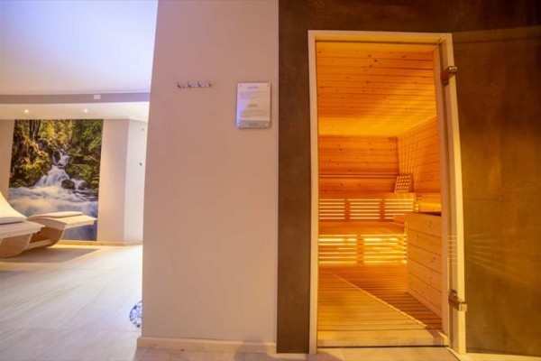 Sauna a relaxační místnost s lehátky a obrazem přírody.
