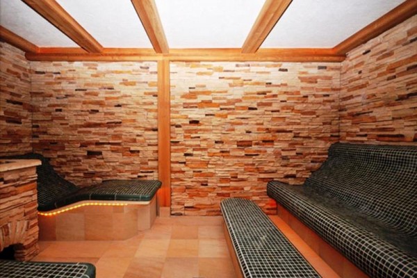 Místnost s keramickými lehátky a stěnami z přírodního kamene.