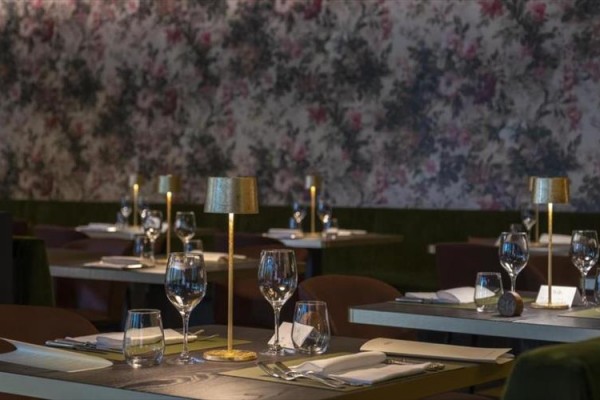 Restaurace s prostřenými stoly a květinovou tapetou.