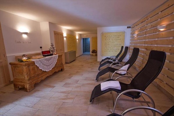 Relaxační místnost s lehátky a dřevěnou komodou.