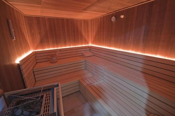 Interiér sauny s lavicemi ze světlého dřeva.