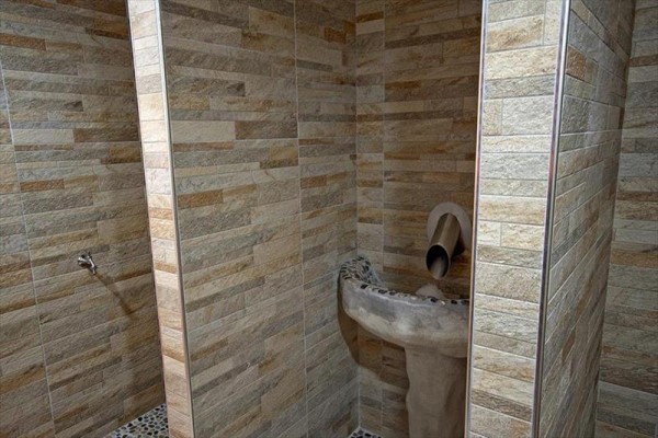 Kamenný umyvadlo v koupelně s obložením z keramických dlaždic.