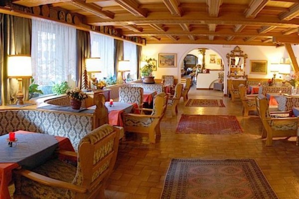 Tradiční restaurace s dřevěným interiérem a útulnými boxy na sezení.