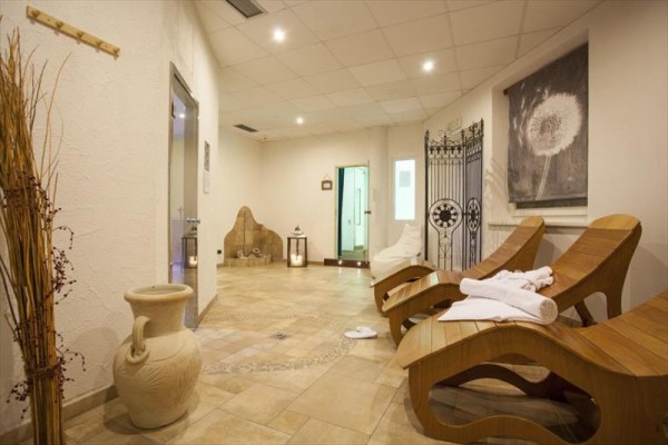Relaxační místnost ve wellness centru s dřevěnými lehátky a dekoracemi.