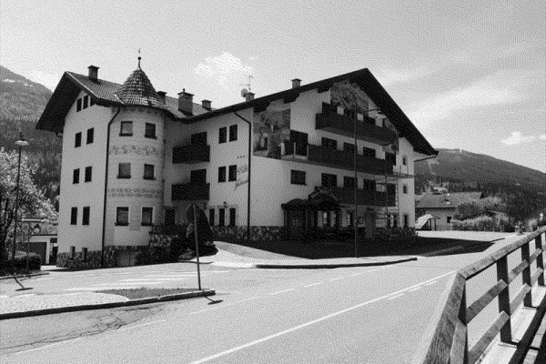 Tradiční vícepatrová budova s věžičkou na venkovské silnici.