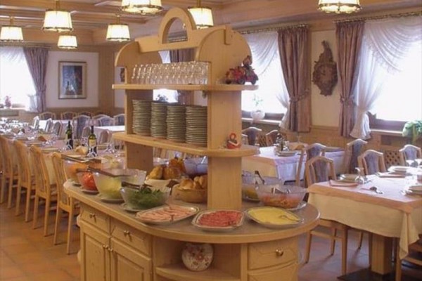 Bufetový stůl s potravinami a nádobím v prostorné jídelně.