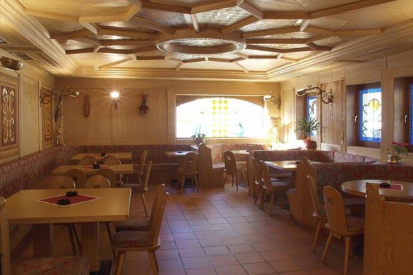 Dřevem obložená útulná restaurace se stoly a židlemi.