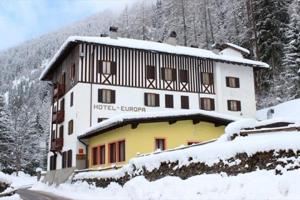 Hotel v zasněžené krajině obklopený lesem.