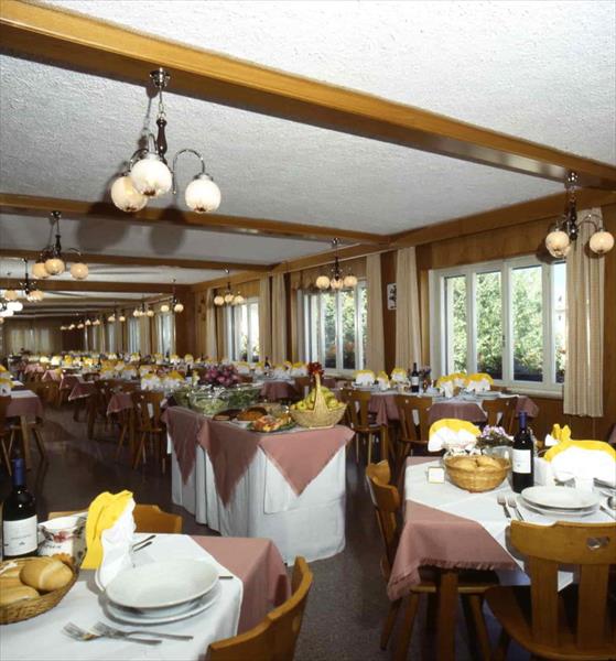 Elegantně prostřená restaurace s připravenými stoly podél velkých oken.