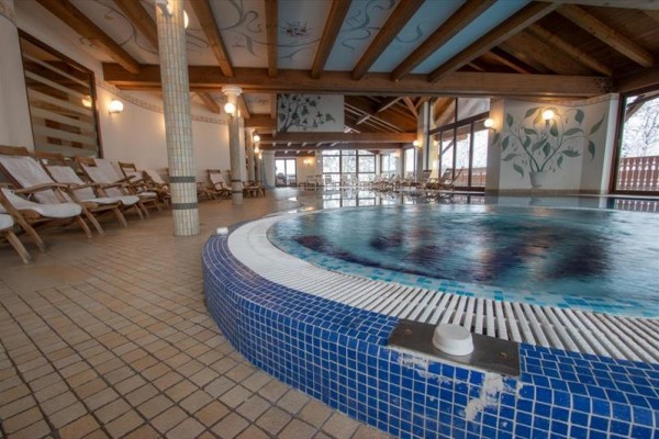 Interiér wellness centra s bazénem a lehátky.
