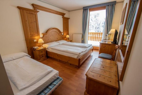 Pokoje v hotelu s dřevěným nábytkem a výhledem na zasněžený balkón.