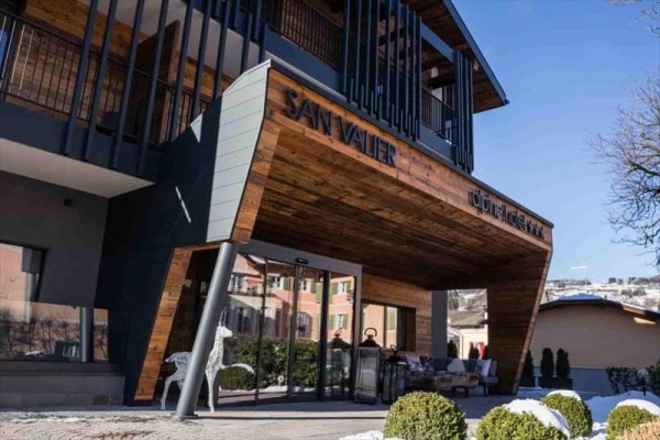 Vstup do horského hotelu San Valier s moderním designem a dřevěnými detaily.