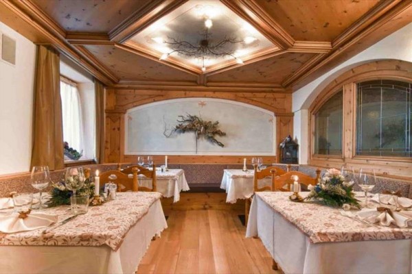 Restaurace s dřevěným obložením a dekorativní výzdobou na stolech.