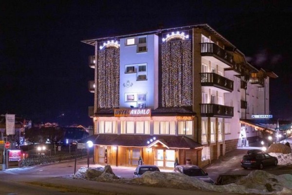 Hotel osvětlený v noci s vánočními světly na fasádě.  