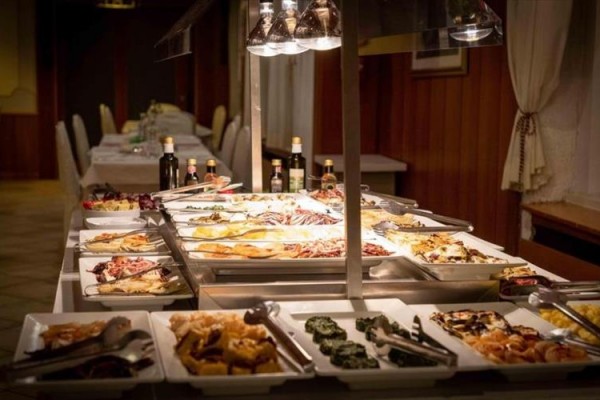 Bufetový stůl s různými pokrmy v restauraci.
