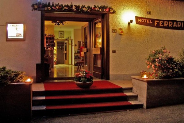 Vstup do hotelu s červeným kobercem a květinovou výzdobou.