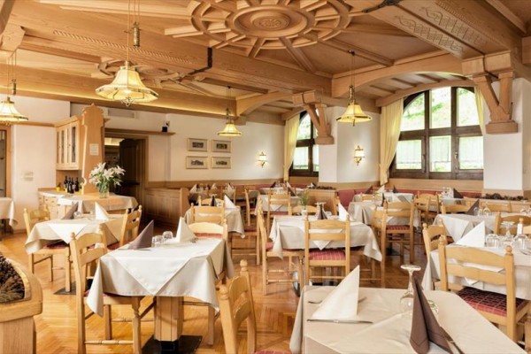 Elegantní restaurace s dřevěným stropem a prostřenými stoly.