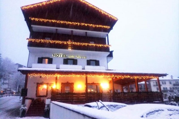 Hotel s vánočními světly pokrytý sněhem.