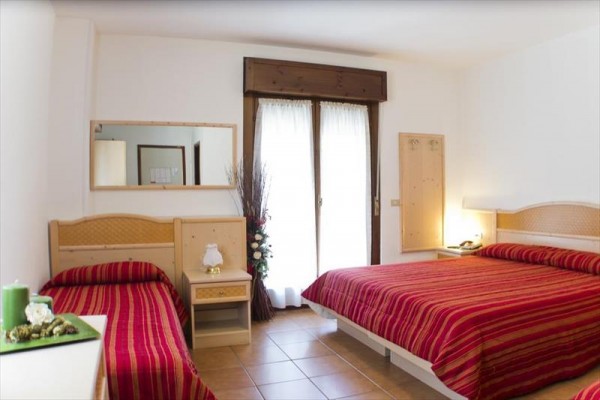 Vstup do hotelu s květinami v popředí.