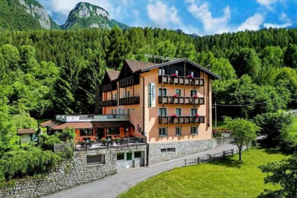 Hotel obklopený lesem a horami.
