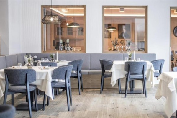 Elegantní restaurace s šedými židlemi a bílými ubrusy.