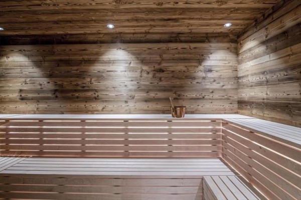 Moderní sauna s dřevěnými stěnami a lavicemi.