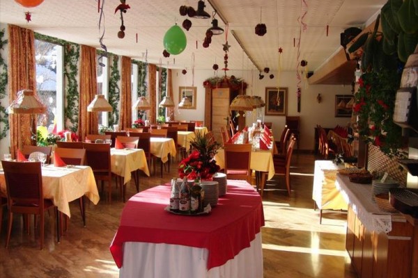 Slavnostně vyzdobená restaurace s prostřenými stoly a dekoracemi.