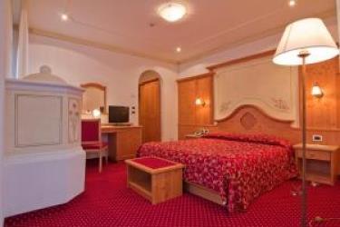 Hotelový pokoj s červeným kobercem a dřevěným nábytkem.  