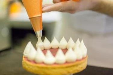 Zdobení dortu šlehačkou pomocí cukrářského sáčku.