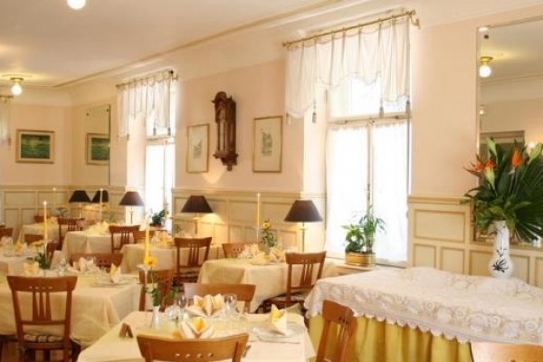 Elegantně zařízená restaurace s prostřenými stoly a dekorativními květinami.