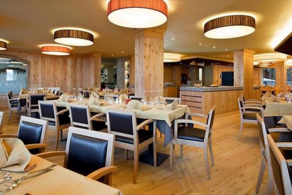 Restaurace s dřevěným interiérem a prostřenými stoly.