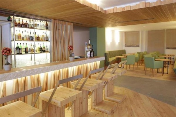 Moderní bar s dřevěnými židlemi a stoly.