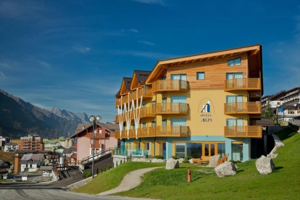 Moderní hotel s dřevěnými balkony na horském úbočí.