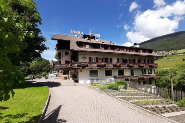 Hotel v alpské krajině s modrou oblohou.