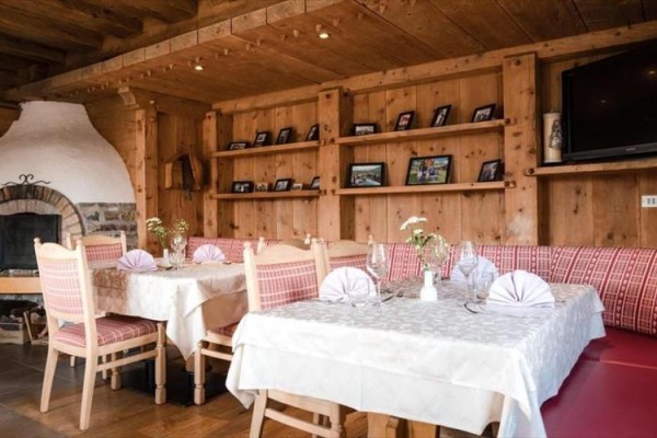 Restaurace v rustikálním stylu s krbem a dřevěným nábytkem.
