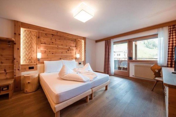 Světlá restaurace s velkými okny s výhledem na krajinu, prostřené stoly a židlemi z lehkého dřeva.  