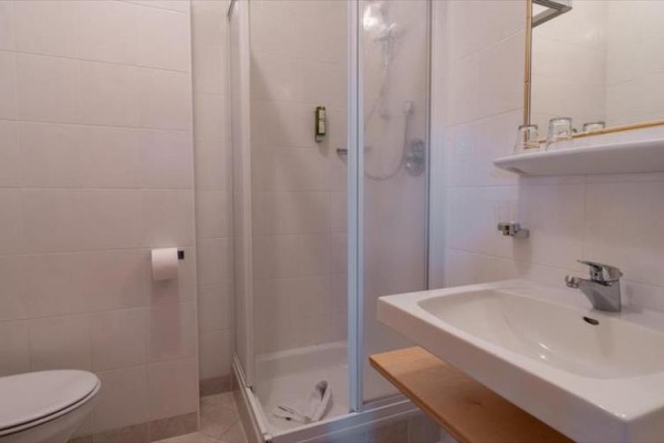 Prostorná restaurace s dřevěným nábytkem a velkými okny.